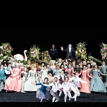 Auf dem Tisch v.l.n.r. Merab (Sarah Brady), Jonathan (Liam Bonthrone), Saul (Christopher Purves) und Michal (Giulia Montanari), davor der Chor der Oper Köln, Tänzer*innen und der Kopf Goliaths