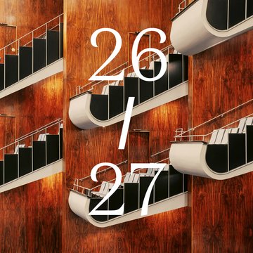 Blick in den modern gestalteten Zuschauerraum der Oper Köln am Offenbachplatz mit warmen Holzvertäfelungen und geschwungenen, übereinander angeordneten Balkonreihen. In der Bildmitte steht groß die Aufschrift „26 / 27“.