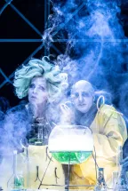 The evil wizards Professor Beelzebub Irrwitzer and Tyrannja Vamperl from the children's opera The Satanarchaeolidealcohellish Wishpotion are brewing the magical Wishpotion. Surrounded by laboratory equipment, glowing green liquids, and thick clouds of smoke, they concentrate on their witch's laboratory experiment.