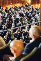 Blick von oben in den dicht besetzten Zuschauerraum des Opernhauses. Das Publikum schaut zur Bühne außerhalb des Bildes.