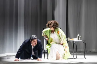 Baron Ochs auf Lerchenau (Patrick Zielke) kneels on the stage floor in front of the seated Marschallin, Princess Werdenberg (Magdalena Hinterdobler). She leans down towards him. A scene from Richard Strauss’s “Der Rosenkavalier”.