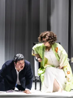 Baron Ochs auf Lerchenau (Patrick Zielke) kneels on the stage floor in front of the seated Marschallin, Princess Werdenberg (Magdalena Hinterdobler). She leans down towards him. A scene from Richard Strauss’s “Der Rosenkavalier”.