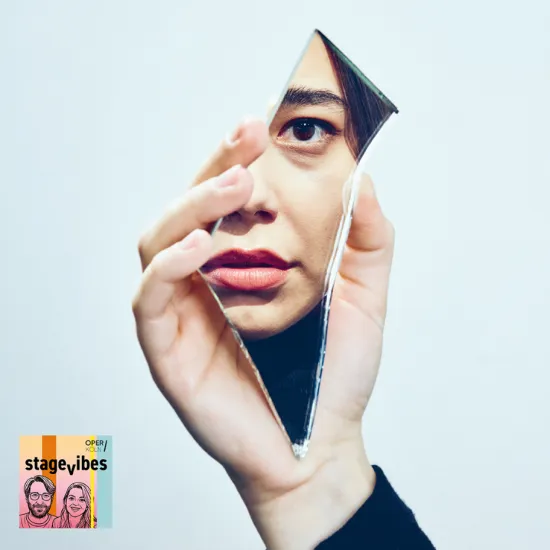 Image from George Benjamin and Martin Crimp’s Picture a Day Like This: A person holds a shard of mirror in front of their face, revealing only part of their features and one eye. The reflection and minimalist composition create an atmosphere of self-reflection, searching, and mystery. The StageVibes logo appears in the lower left corner of the image.