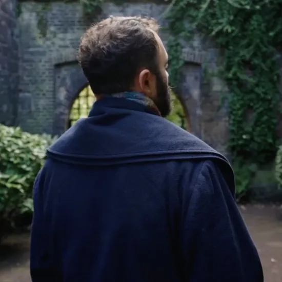 Bass-baritone William Socolof stands with his back to the camera in front of an ivy-covered brick archway at Fort X.