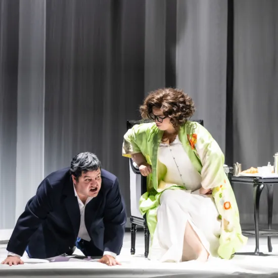 Baron Ochs auf Lerchenau (Patrick Zielke) kneels on the stage floor in front of the seated Marschallin, Princess Werdenberg (Magdalena Hinterdobler). She leans down towards him. A scene from Richard Strauss’s “Der Rosenkavalier”.