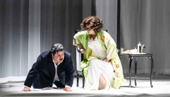 Baron Ochs auf Lerchenau (Patrick Zielke) kniet vor der sitzenden Feldmarschallin Fürstin Werdenberg (Magdalena Hinterdobler) auf dem Bühnenboden. Sie beugt sich zu ihm hinab. Szene aus Richard Strauss’ „Der Rosenkavalier“.